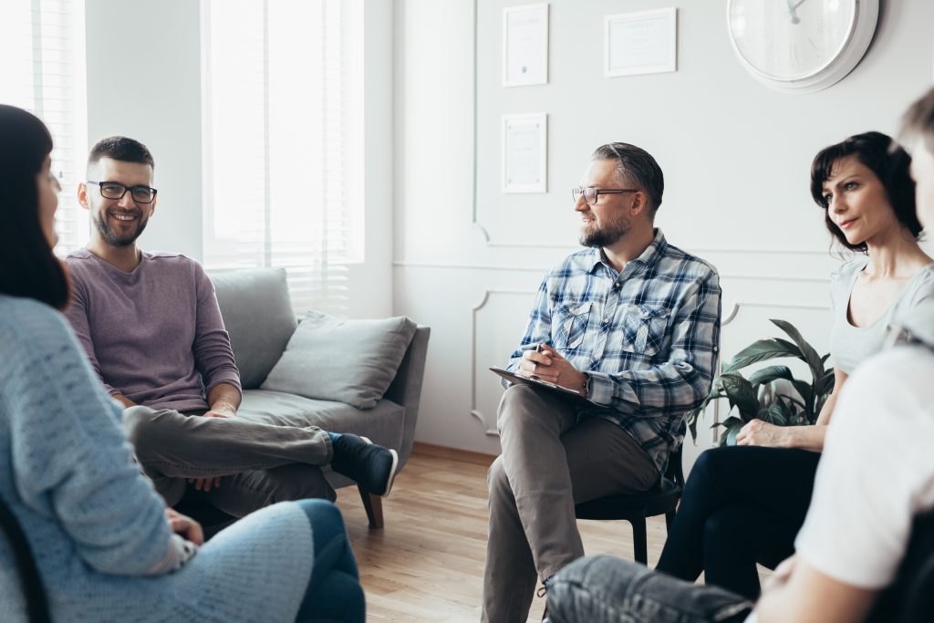 A diverse group of people engaged in conversation while sitting in a circle, sharing ideas and experiences with marijuana use.
