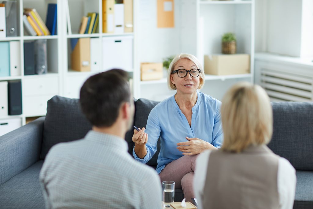A woman engages in conversation with teens, sharing ideas in a lively discussion about Understanding Opioid Use Disorders in Teens.