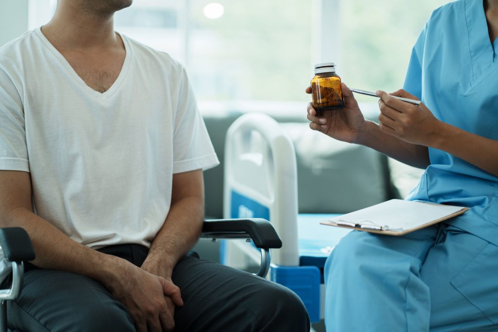 Nurse giving pills to a patient.