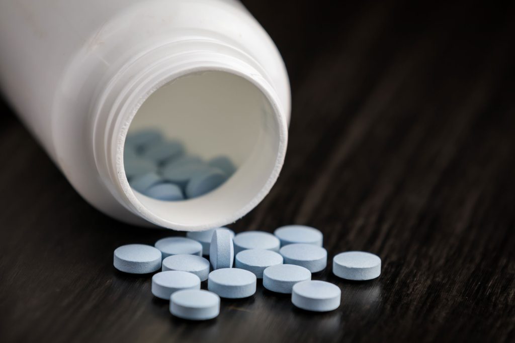 Benzodiazepine pills in a wooden floor.
