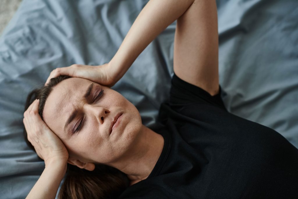 Stressed woman lying in bed.