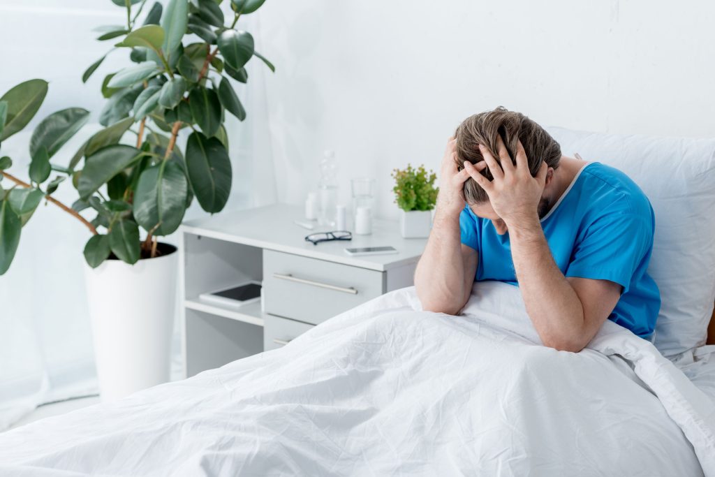 Patient with Post-Acute Withdrawal Syndrome holding his hair.