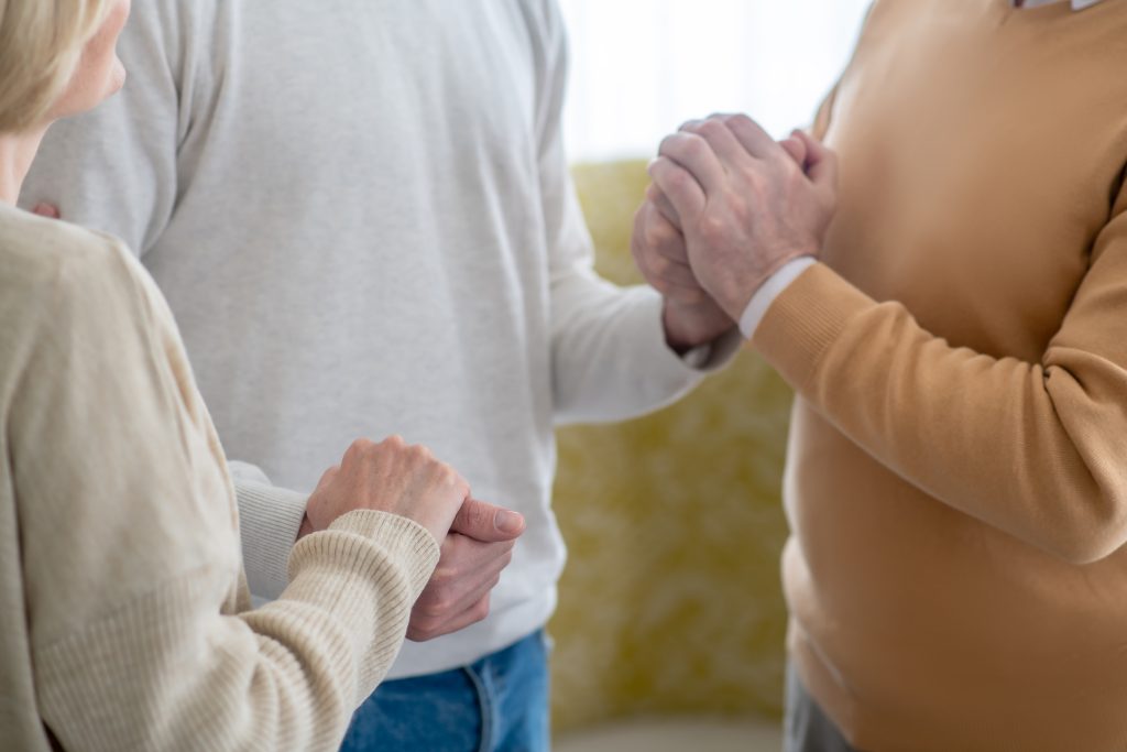 A man and woman are holding hands with their son, representing a bond of togetherness Overcoming Sedative Addiction.
