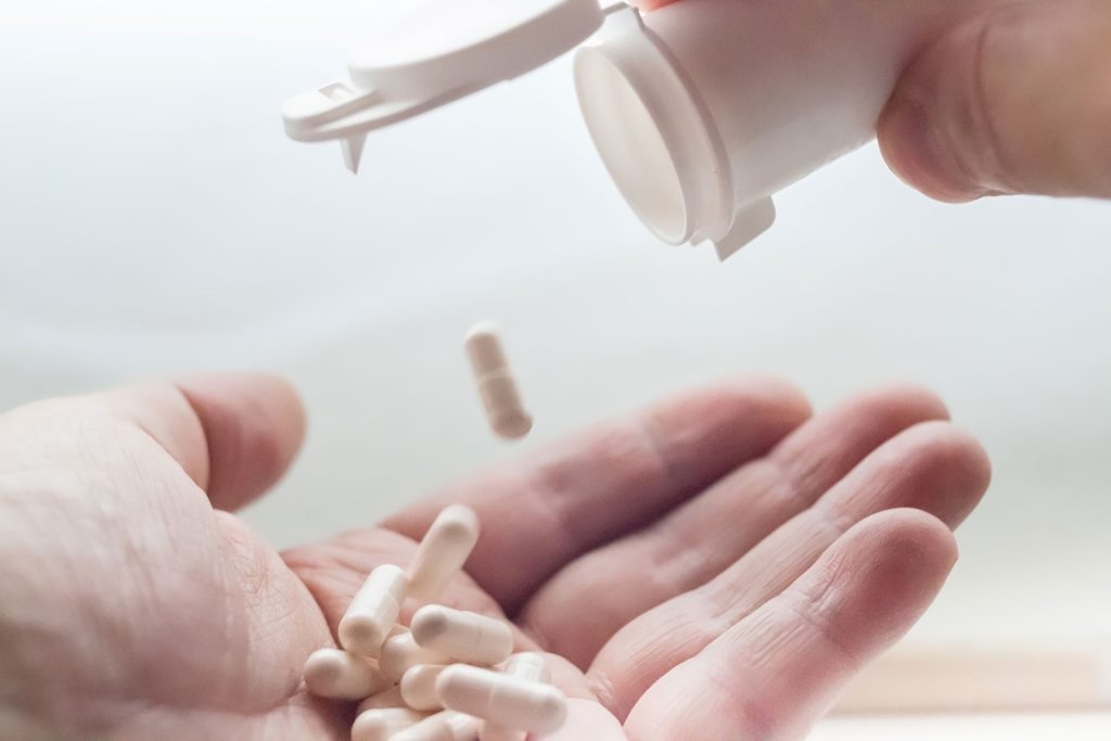 Pills dropping from container.