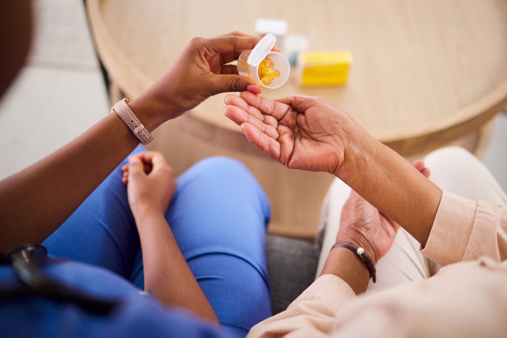 Woman hands and nurse with pills for patient.