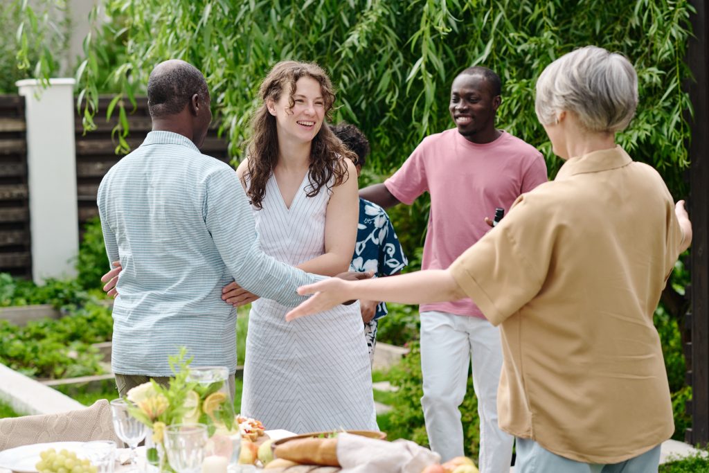 A group of people gathered around a table filled with various dishes, engaging in conversation and enjoying the meal together.