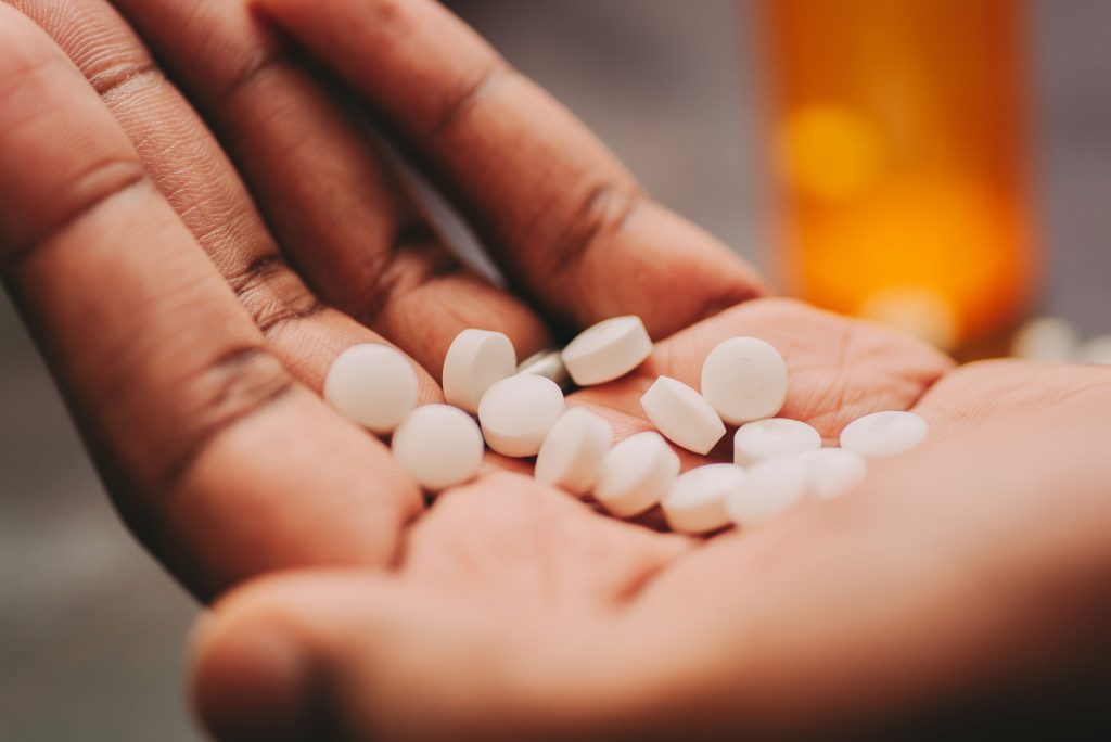 Hands holding pills.