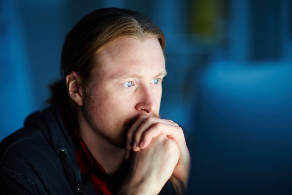 Man looking depressed looking at something.