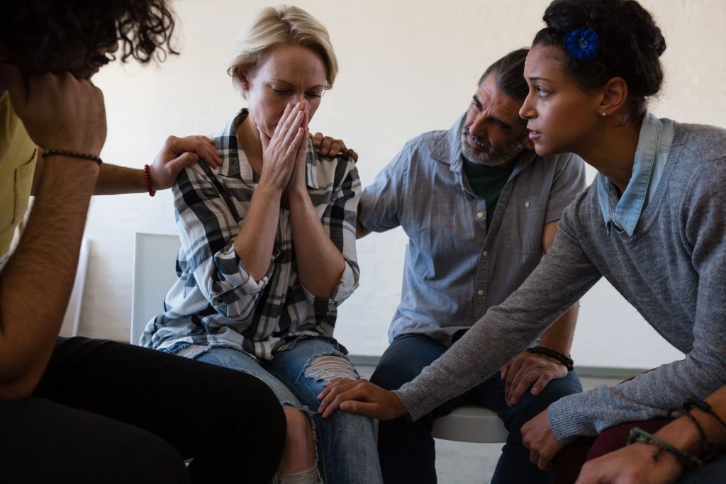Friends consoling woman with GAD.