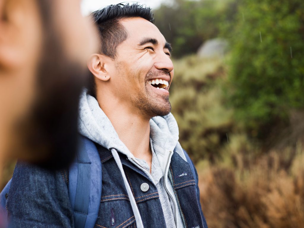 Two men laughing outdoor.